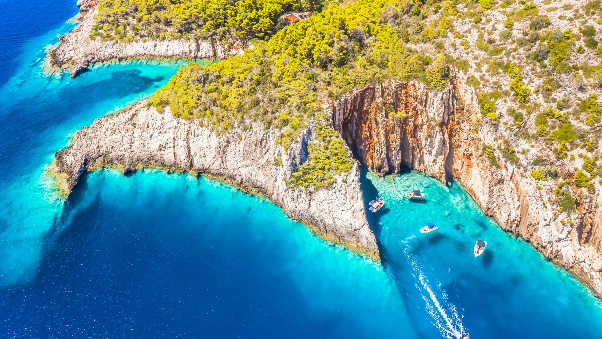 A stunning view of the Red Rocks Plaza and rugged cliffs on Hvar Island, Croatia, showcasing dramatic red limestone formations, crystal-clear Adriatic waters, and breathtaking coastal scenery.