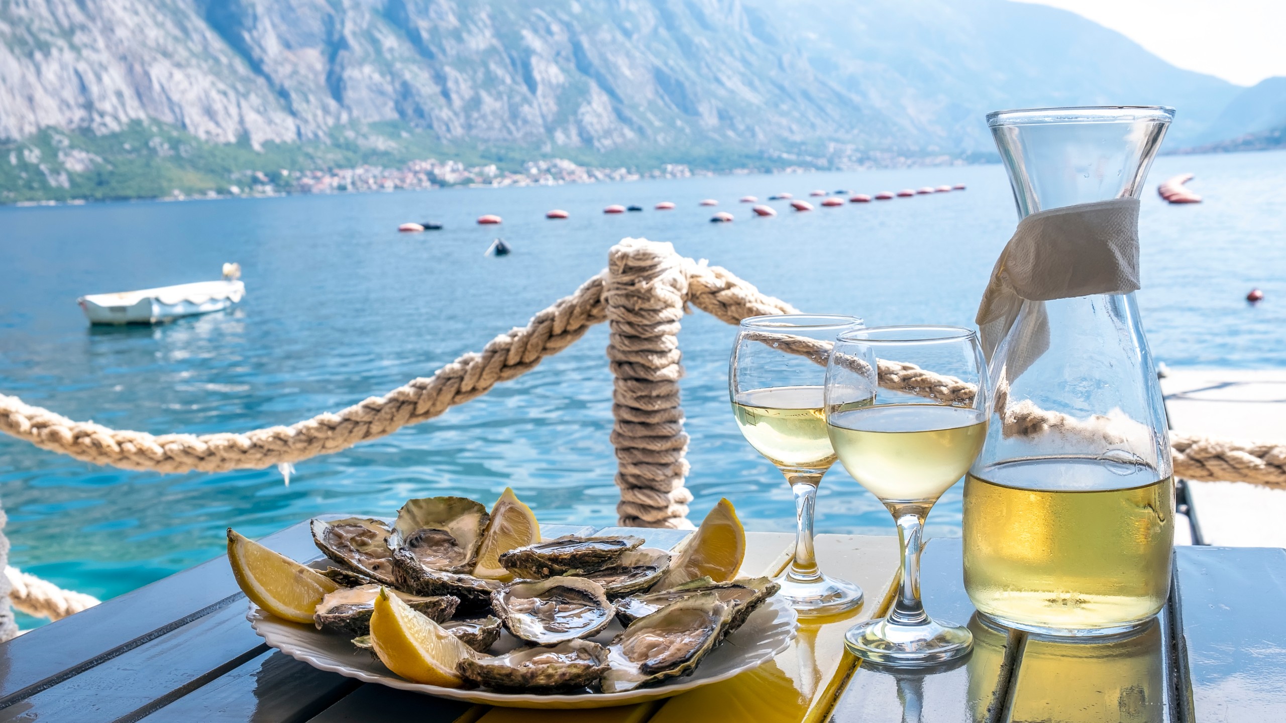 Oysters and white wine in a restaurant with a sea view.